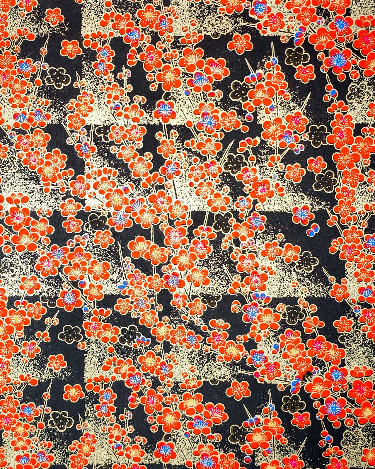 Japanese chiyogami featuring red plum blossoms with a little bit of blue on a black background with metallic gold accents.