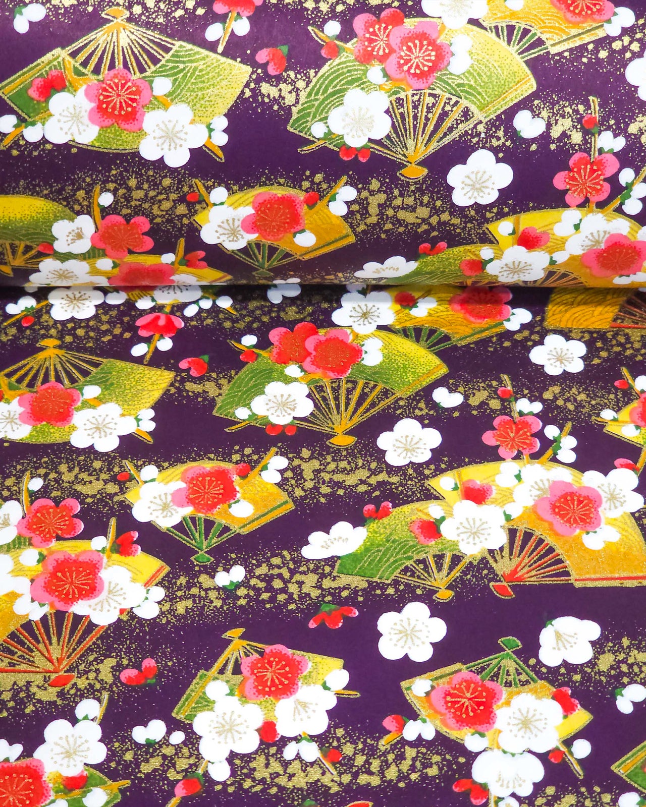 Japanese chiyogami paper featuring green & yellow hand fans with pink & white plum blossoms on a purple background with metallic gold accents.