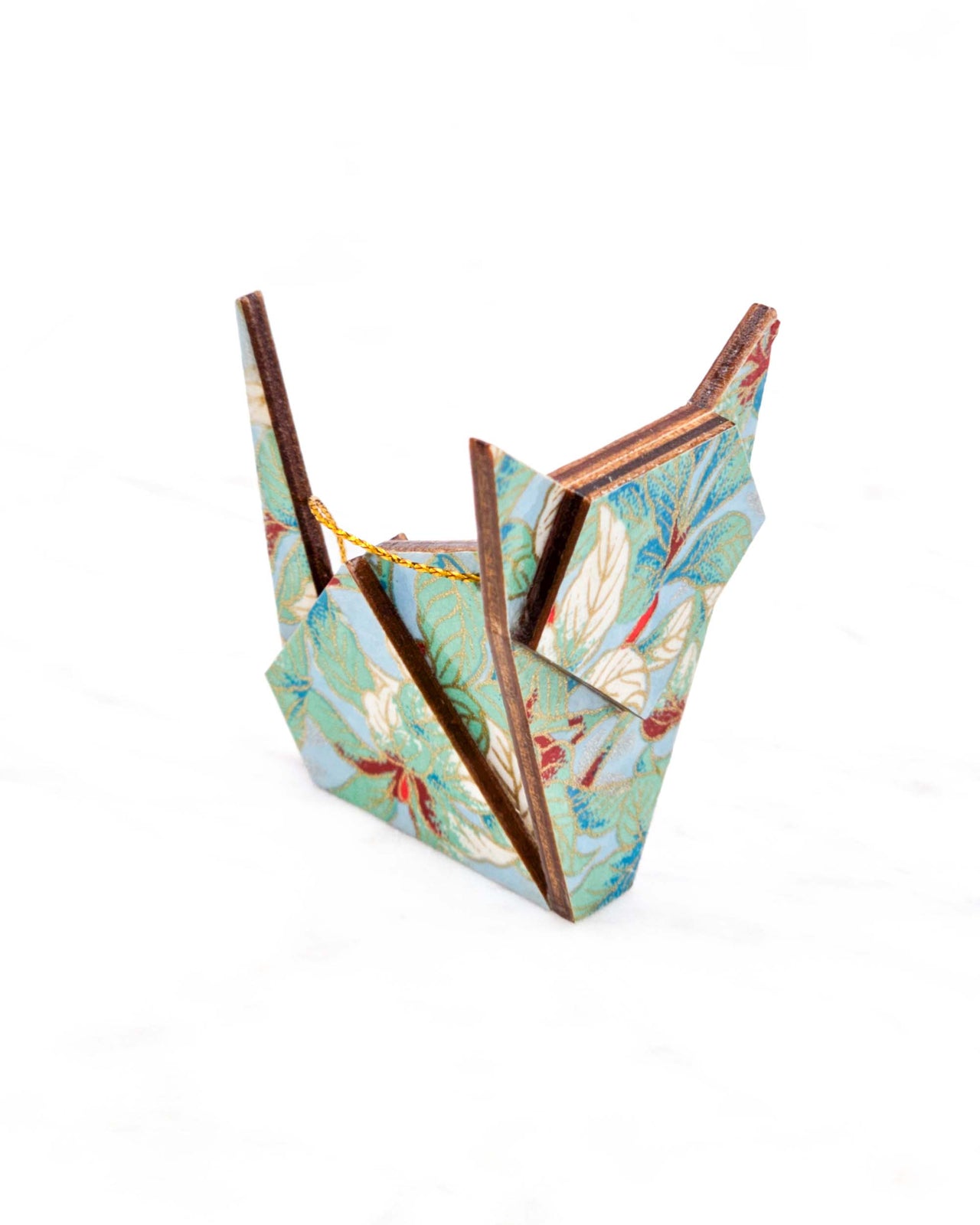 Small wooden origami cat ornament featuring green, white, red, and silver leaves on a light blue background with metallic gold details.