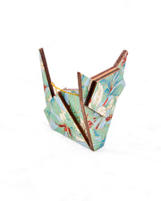 Small wooden origami cat ornament featuring green, white, red, and silver leaves on a light blue background with metallic gold details.