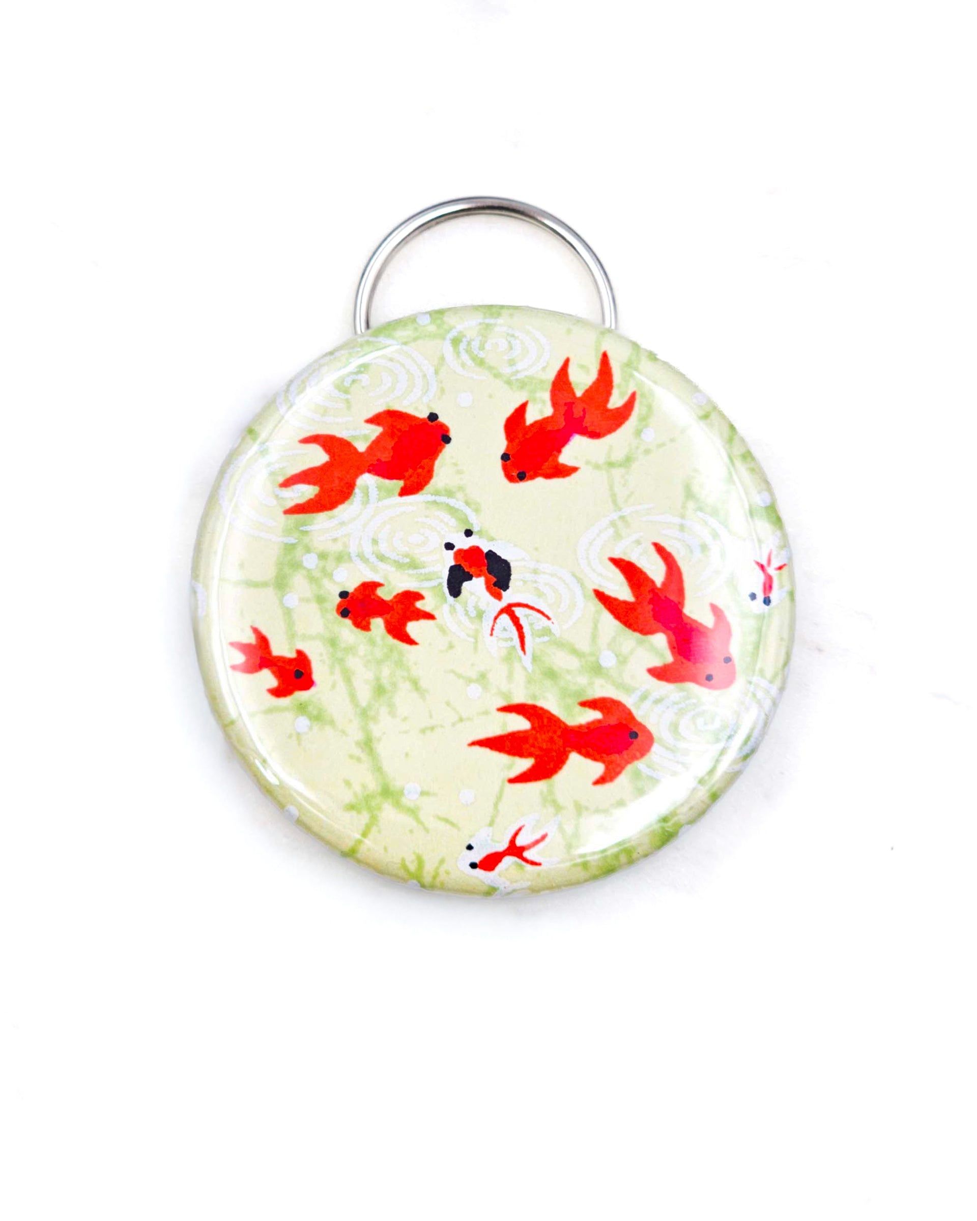 Magnetic bottle opener featuring red and white fishes on a green background.