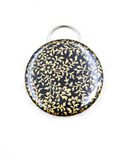 Magnetic bottle opener featuring a metallic gold floral design on a black background.