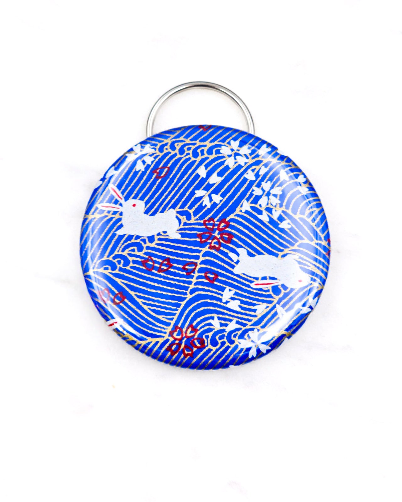 Magnetic bottle opener featuring white rabbits and cherry blossoms on a blue wave background with metallic gold accents.