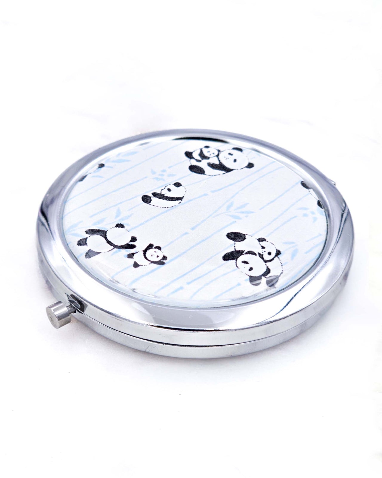 Silver metal compact mirror featuring pandas and blue bamboo on a pearlescent white background.
