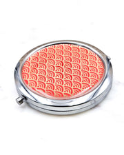 Round silver metal compact mirror featuring a small traditional red and metallic gold seigaiha (wave crests) pattern.