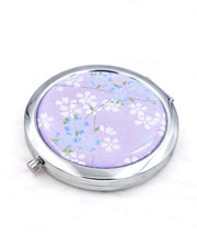 Silver metal compact mirror featuring white and blue cherry blossoms on a pearlescent purple background.