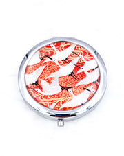 Silver metal compact mirror featuring flying white cranes on a red background with metallic gold accents