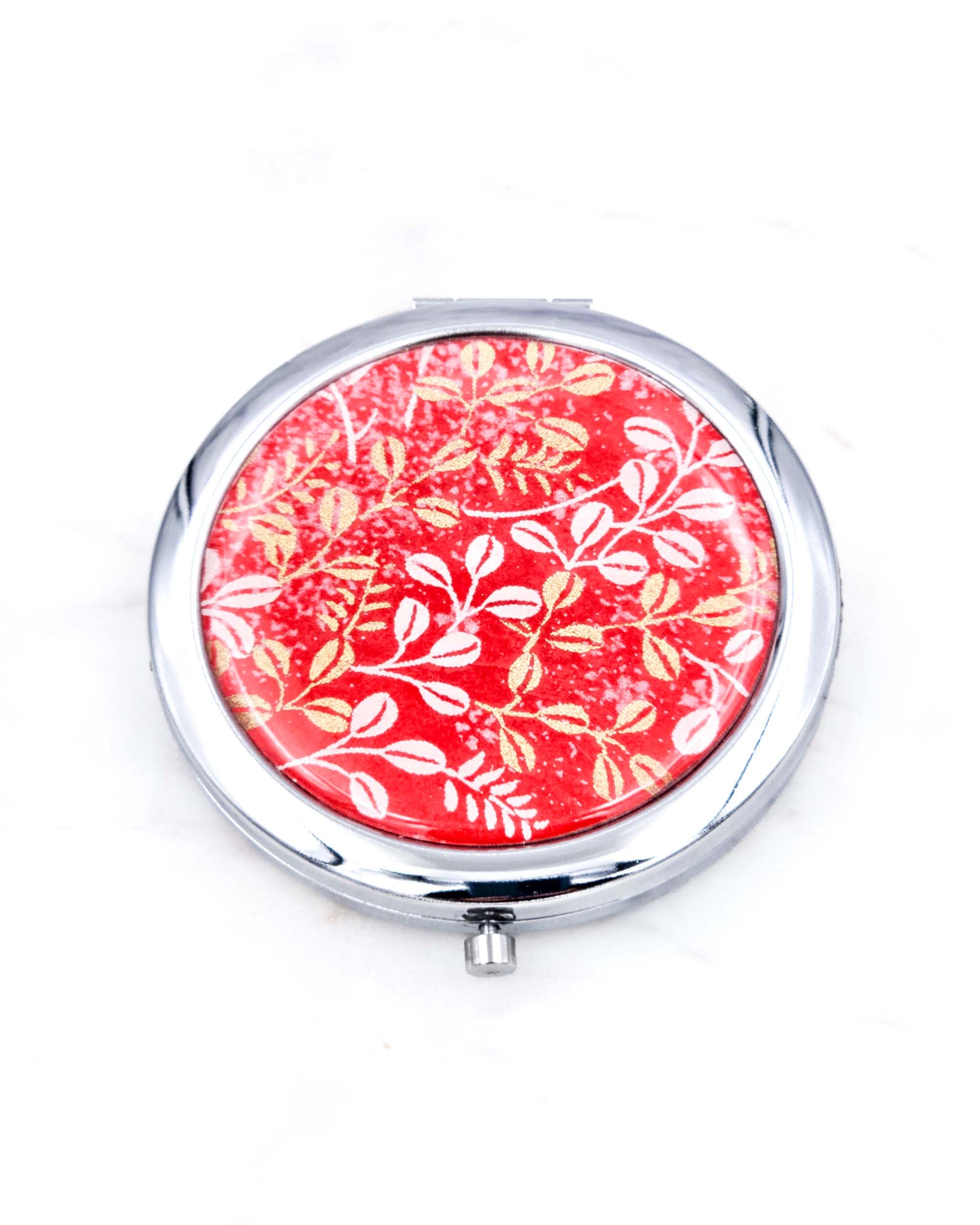 Silver metal compact mirror featuring white and metallic gold hagi blush clover on a red background.