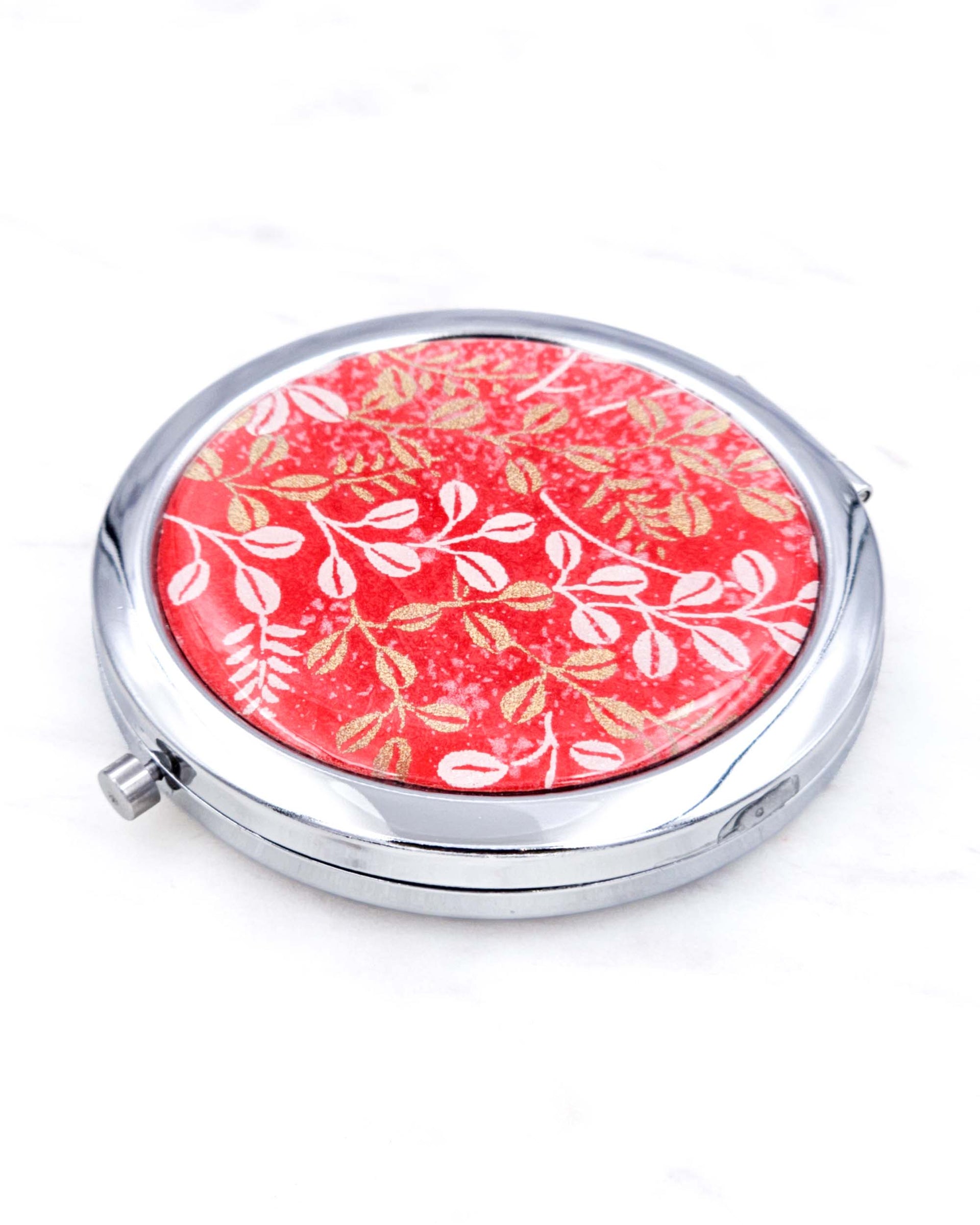 Silver metal compact mirror featuring white and metallic gold hagi blush clover on a red background.