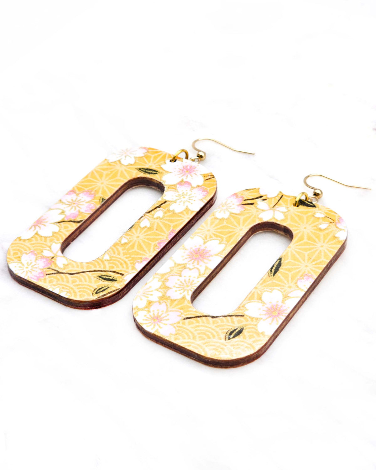 Large wooden hollow rounded rectangular earrings featuring pink cherry blossoms on an orange background with metallic gold details.