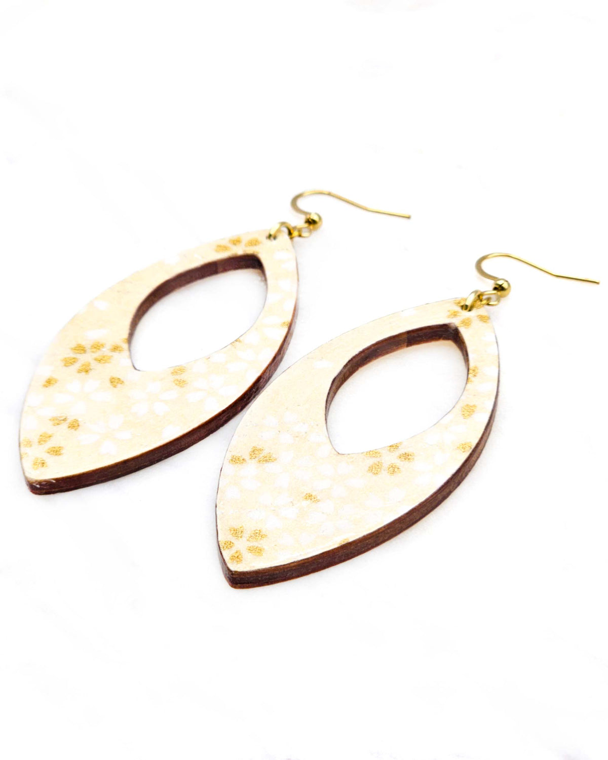 Large wooden hollow pointed oval shaped earrings featuring small white and metallic gold cherry blossoms on pearlescent cream background with metallic silver details.