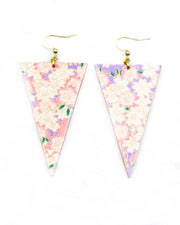 Large wooden long triangle shaped earrings featuring pink and white cherry blossoms on a pearlescent light purple background with metallic gold details.