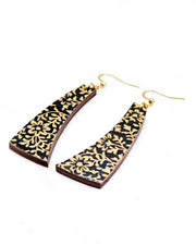 Medium wooden curved bar shaped earrings featuring a metallic gold floral motif on a black background.