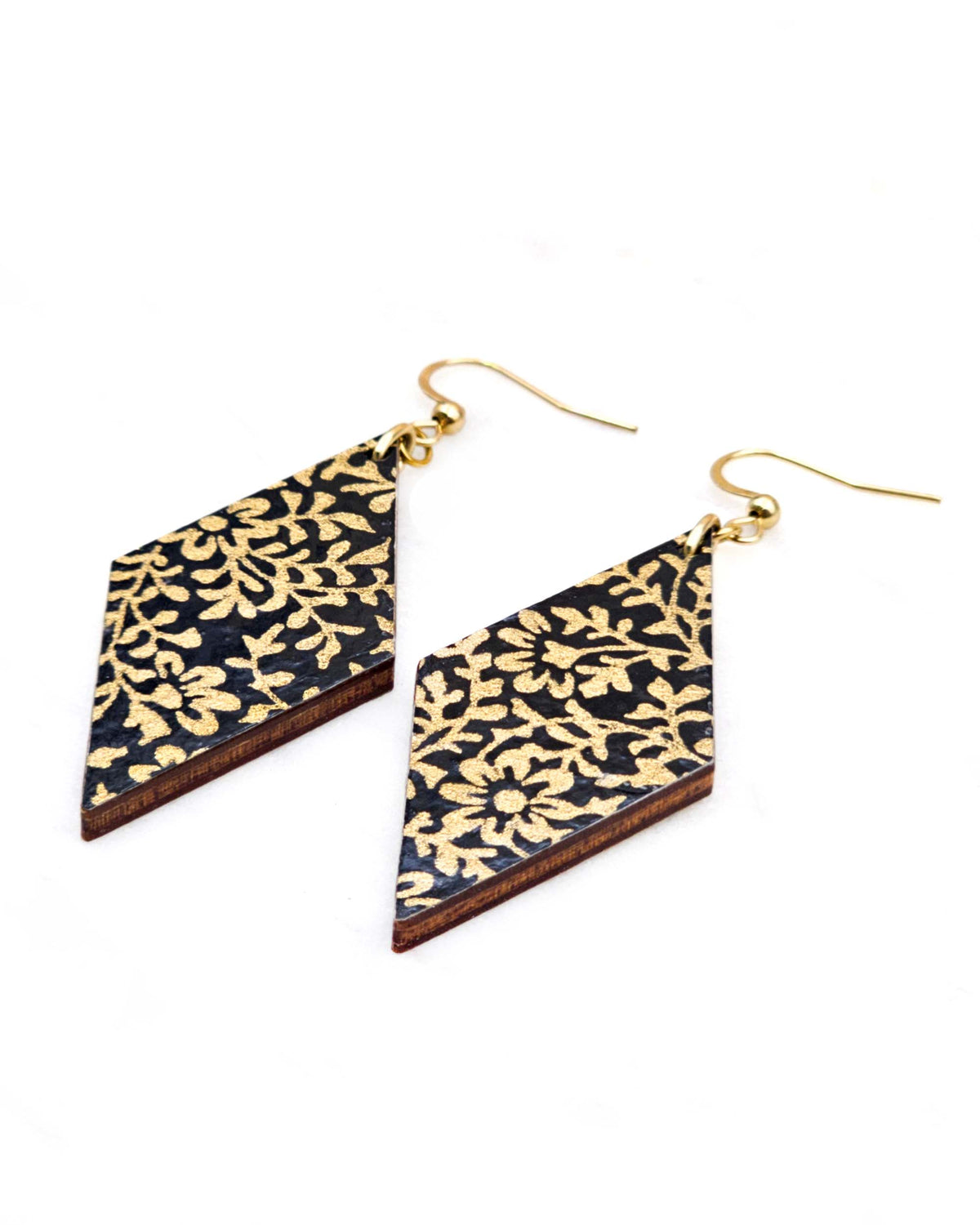 Medium wooden diamond shaped earrings featuring a metallic gold floral design on a black background.