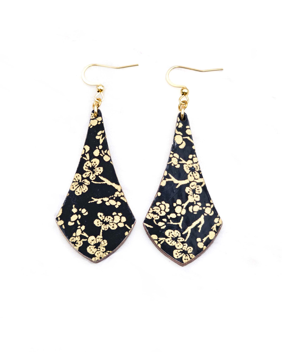 Medium wooden long anchor shaped earrings featuring small metallic gold plum blossom branches on a black background.