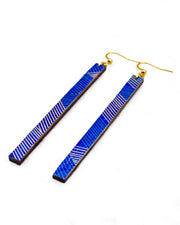Medium wooden long thin bar shaped earrings featuring a metallic gold and dark green line pattern on a blue background.