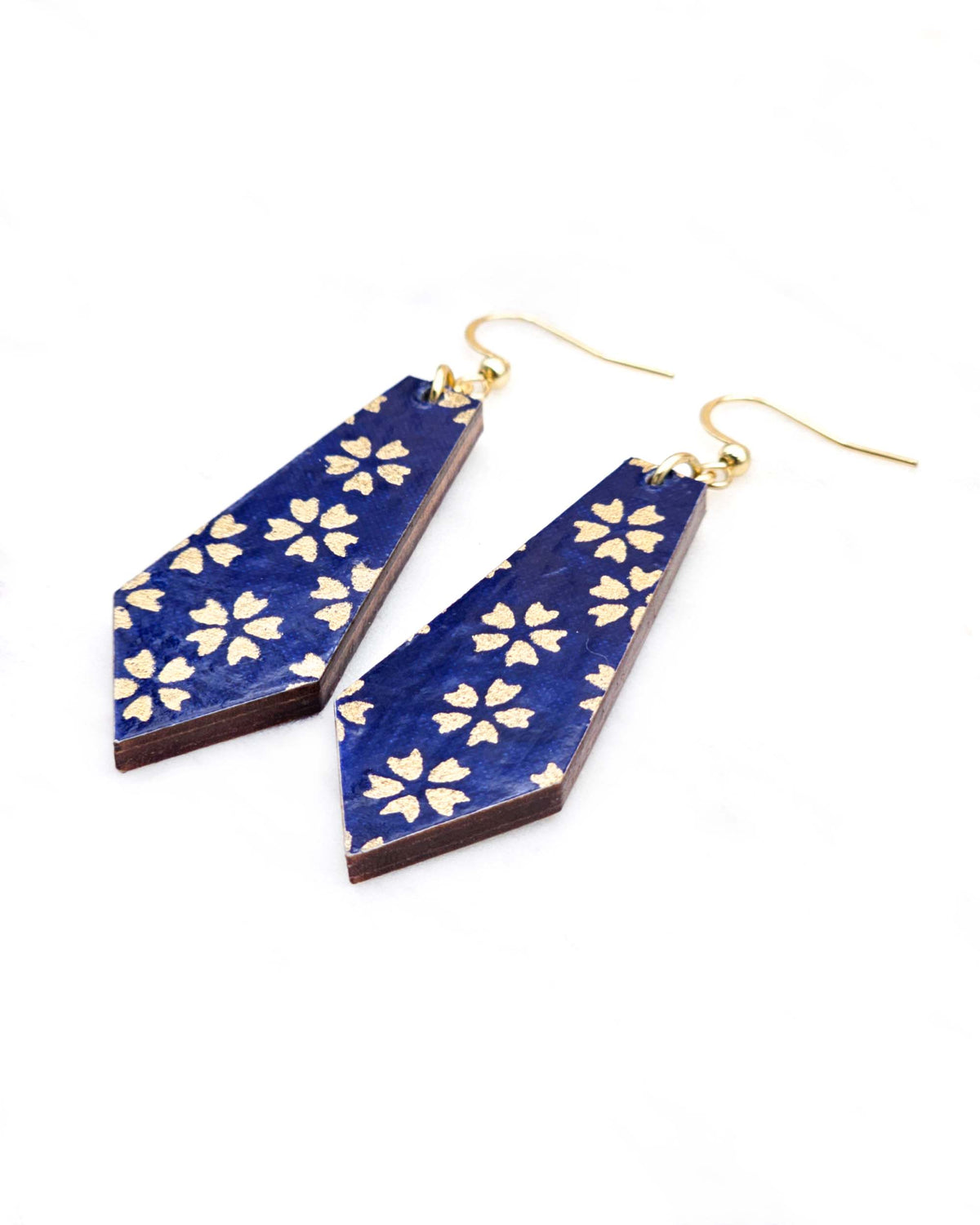 Medium wooden pointed tapered bar shaped earrings featuring metallic gold cherry blossoms on a dark blue background.