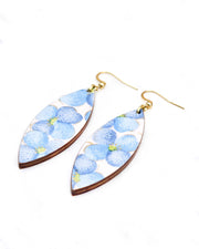 Medium wooden thin pointed oval shaped earrings featuring blue flowers on a pink background with metallic gold details.