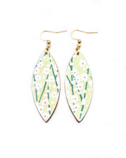 Medium wooden thin pointed oval shaped earrings featuring small white flower bushes with green stems over a yellow green background with metallic gold details.