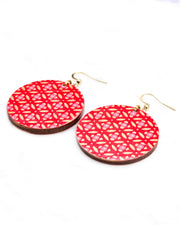 Medium wooden circle shaped earrings featuring a gold shippo design with pink centers on a red background