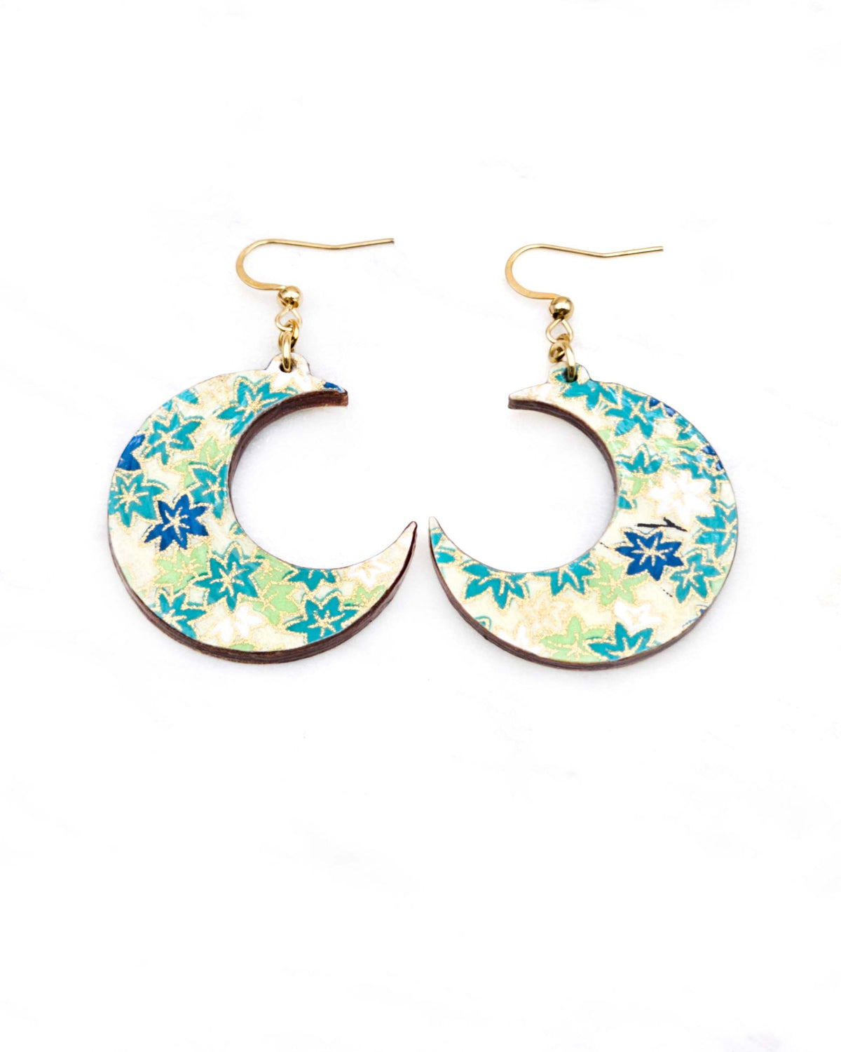 Medium wooden crescent moon shaped earrings featuring small green and white momiji (maple leaves) on a light green background with metallic gold details.