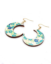 Medium wooden crescent moon shaped earrings featuring small green and white momiji (maple leaves) on a light green background with metallic gold details.