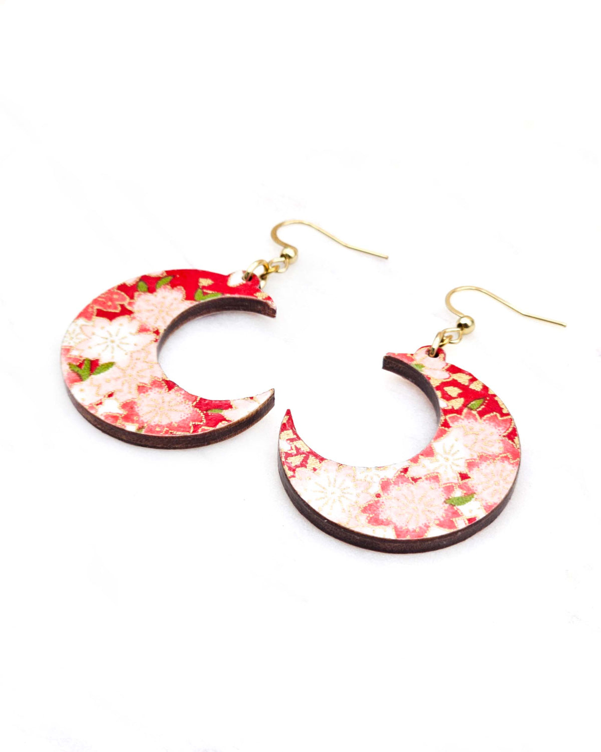 Medium wooden crescent moon shaped earrings featuring red and white cherry blossoms on a red background with metallic gold details.