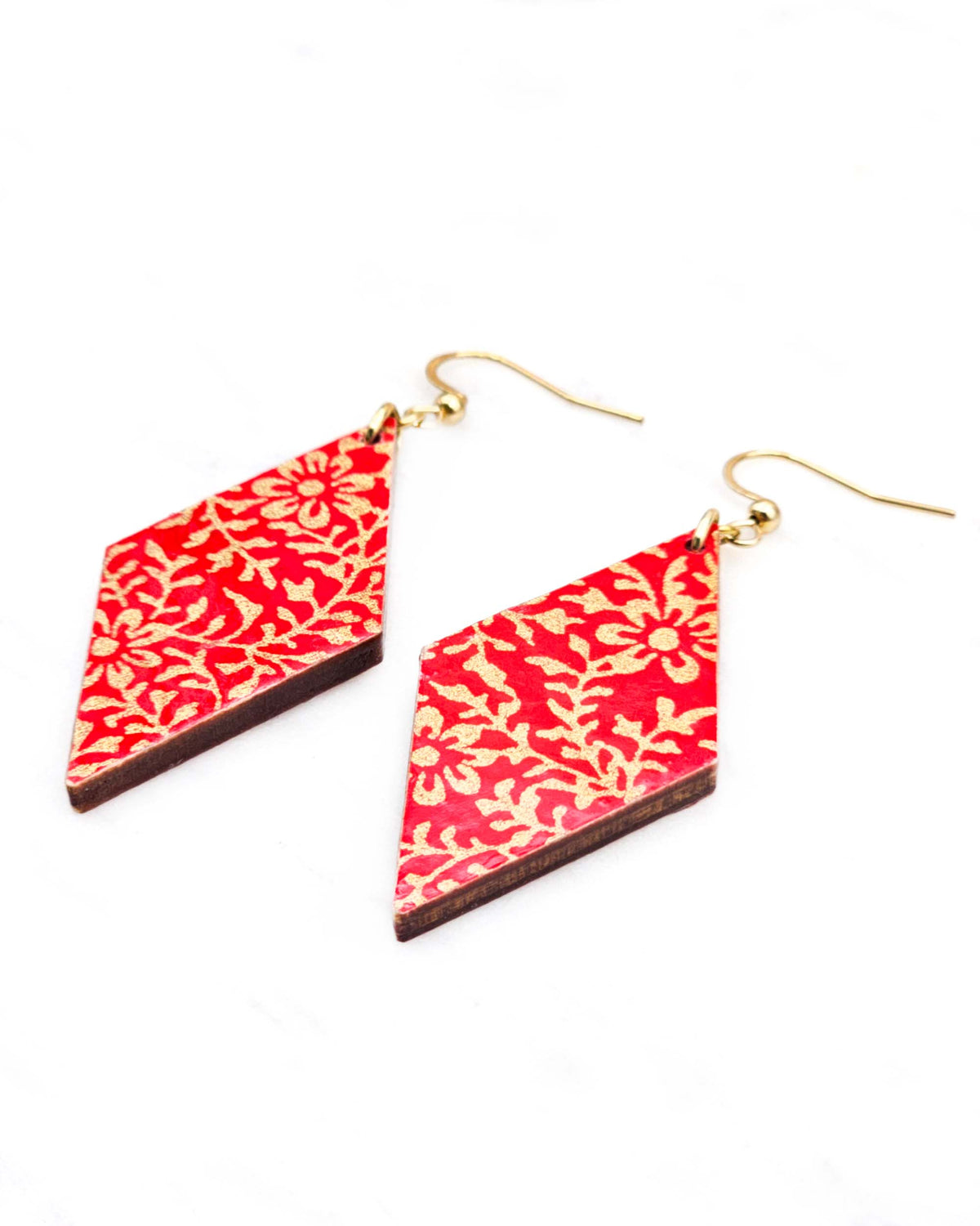 Medium wooden diamond shaped earrings featuring a metallic gold floral motif on a bright red background.