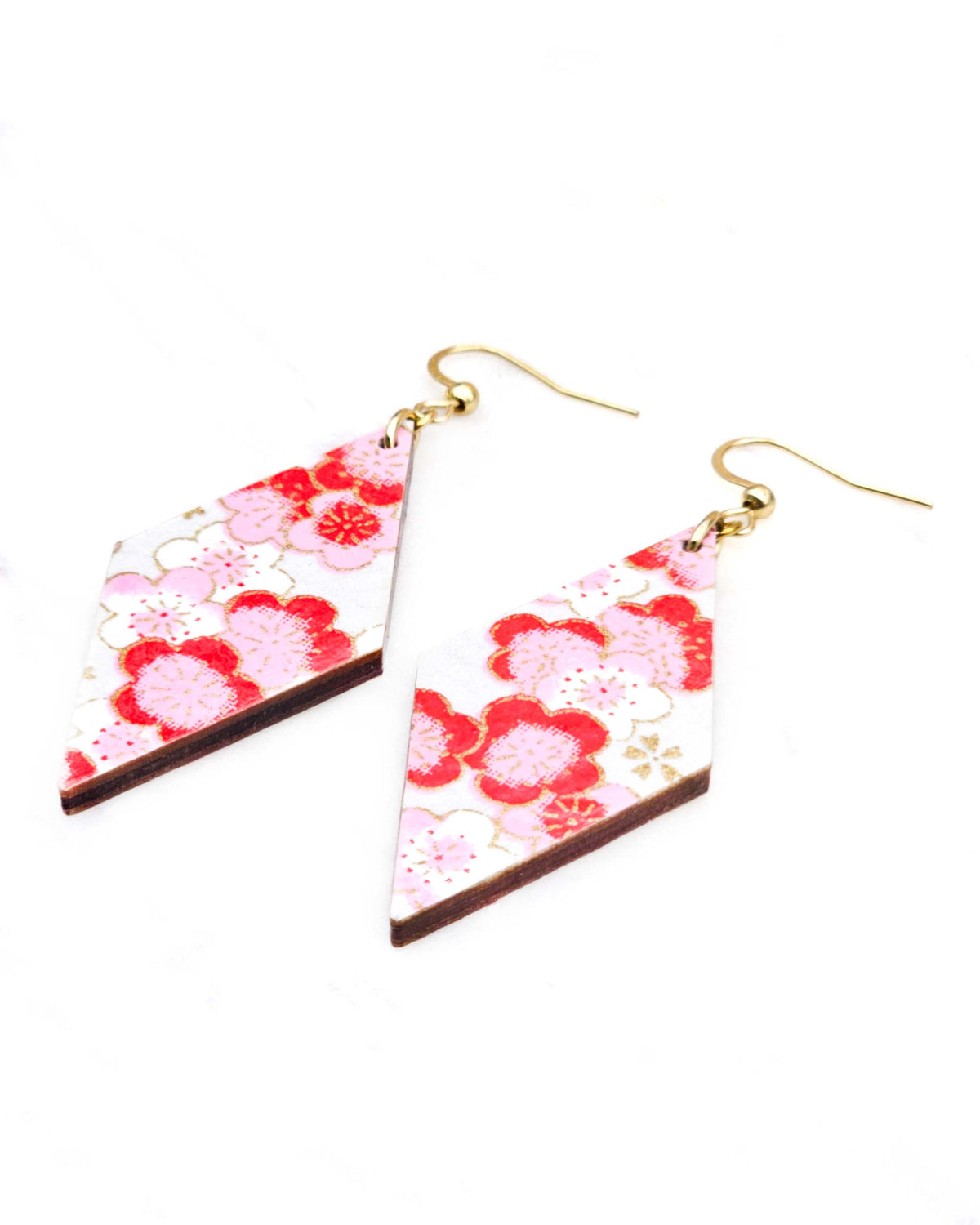 Medium wooden diamond shaped earrings featuring pink plum blossoms on a pearlescent white background with metallic gold accents.