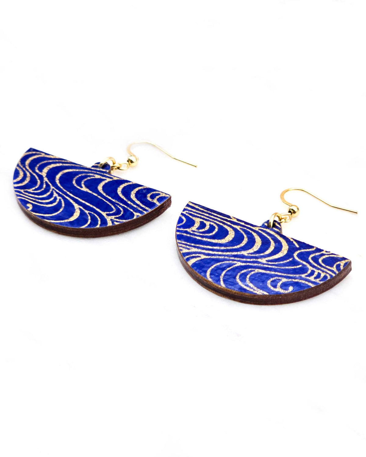 Medium wooden half circle shaped earrings featuring metallic gold water ripples on a dark blue background.