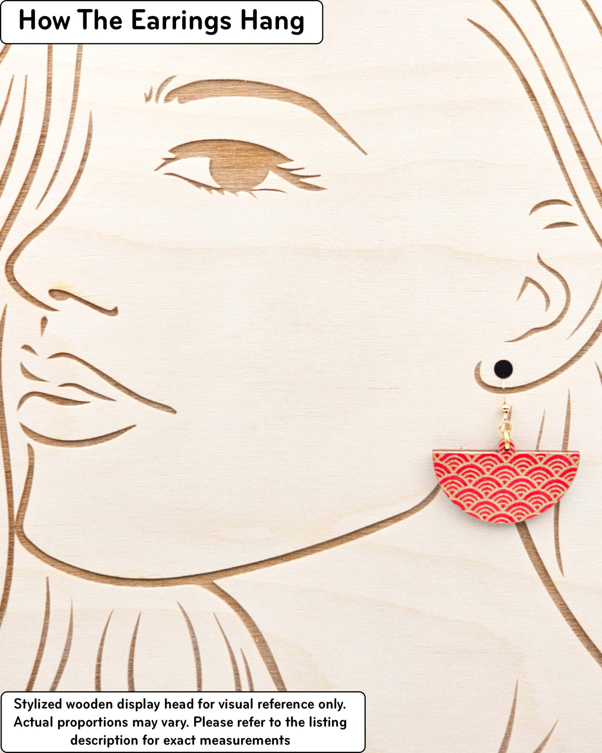 Medium wooden half circle shaped earrings featuring a traditional red and metallic gold seigaiha (wave crests) pattern, displayed on a stylized wooden head to demonstrate how the earring hangs when worn. Display is not to scale.