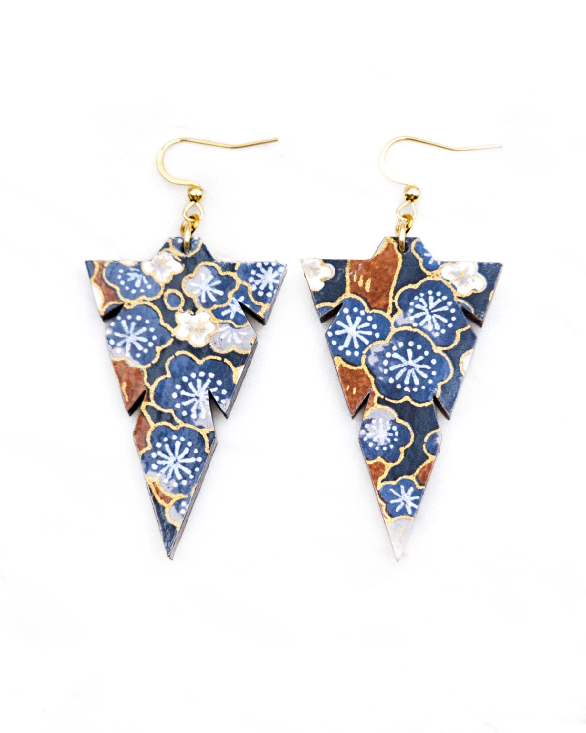 Medium wooden notched triangle shaped earrings featuring blue and gray plum blossoms with brown branches on a dark blue background with metallic gold details.