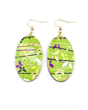 Medium wooden oval shaped earrings featuring small white cherry blossoms and cherry blossom outlines on a red background.