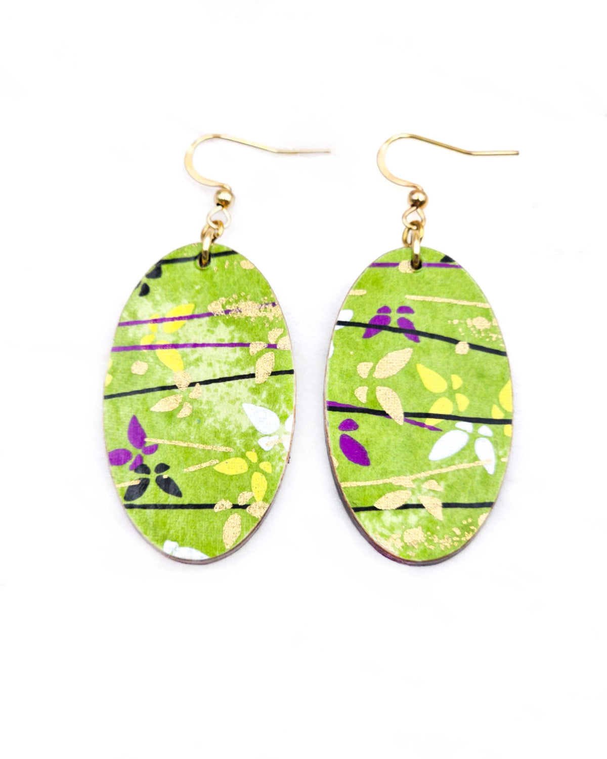 Medium wooden oval shaped earrings featuring small white cherry blossoms and cherry blossom outlines on a red background.