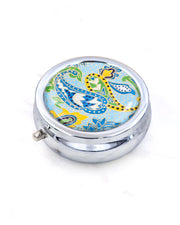 Silver metal pill box featuring a green and yellow paisley design on a light blue background with metallic gold accents.