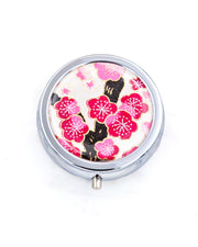 Silver metal pill box featuring a pink plum blossom tree on a white background with metallic gold accents.