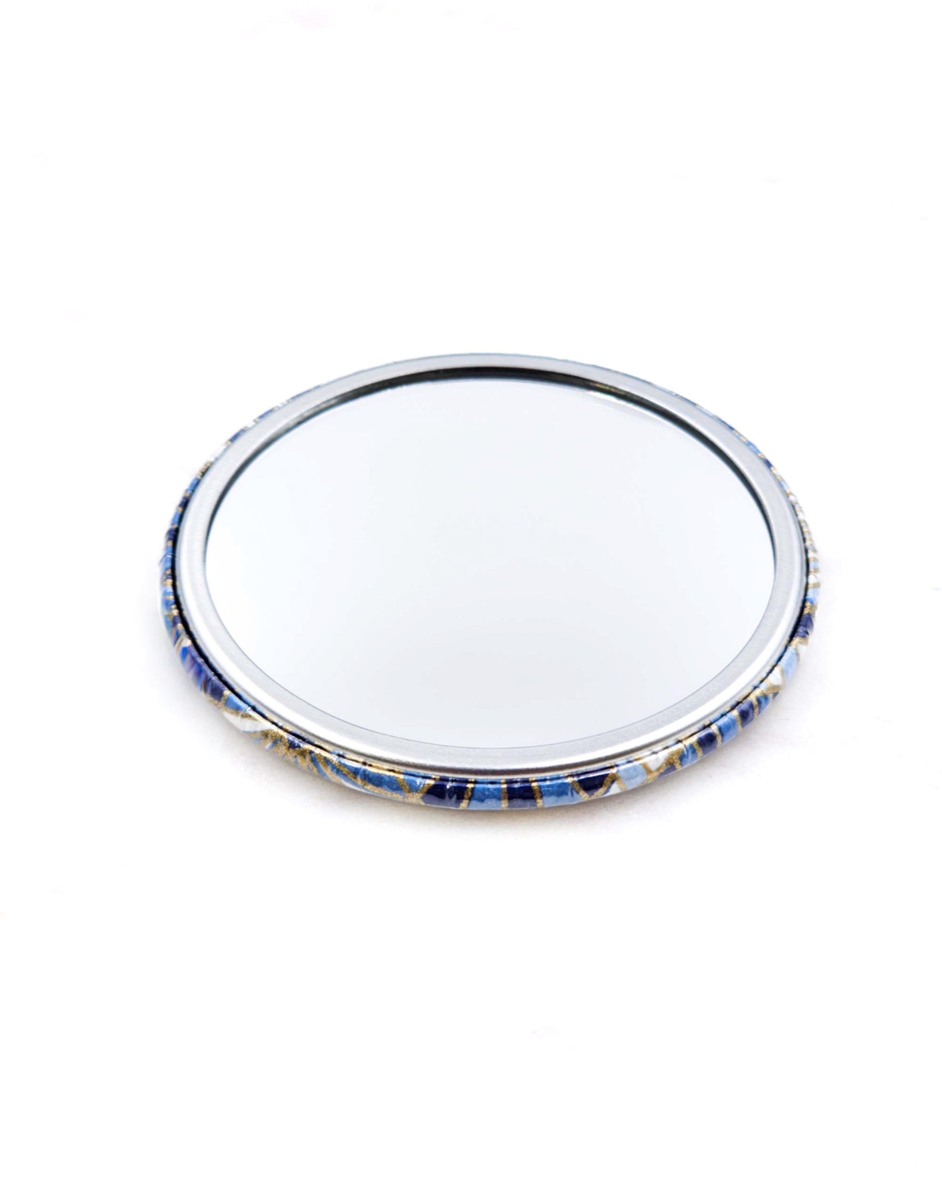 Round pocket mirror featuring blue and white abstract parasols with metallic gold accents.