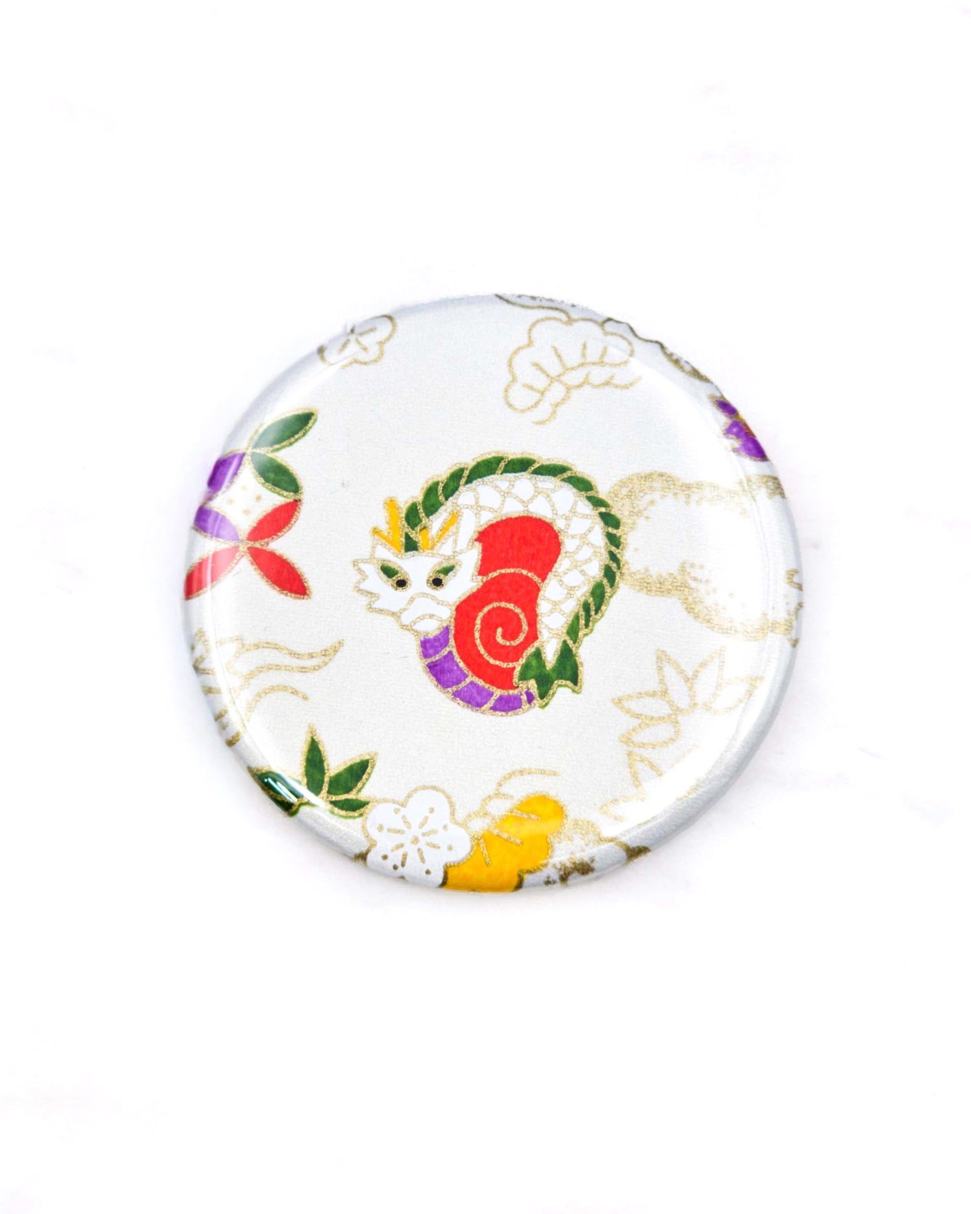 Round pocket mirror featuring a cute red, green, and white dragon on a white background with metallic gold accents.
