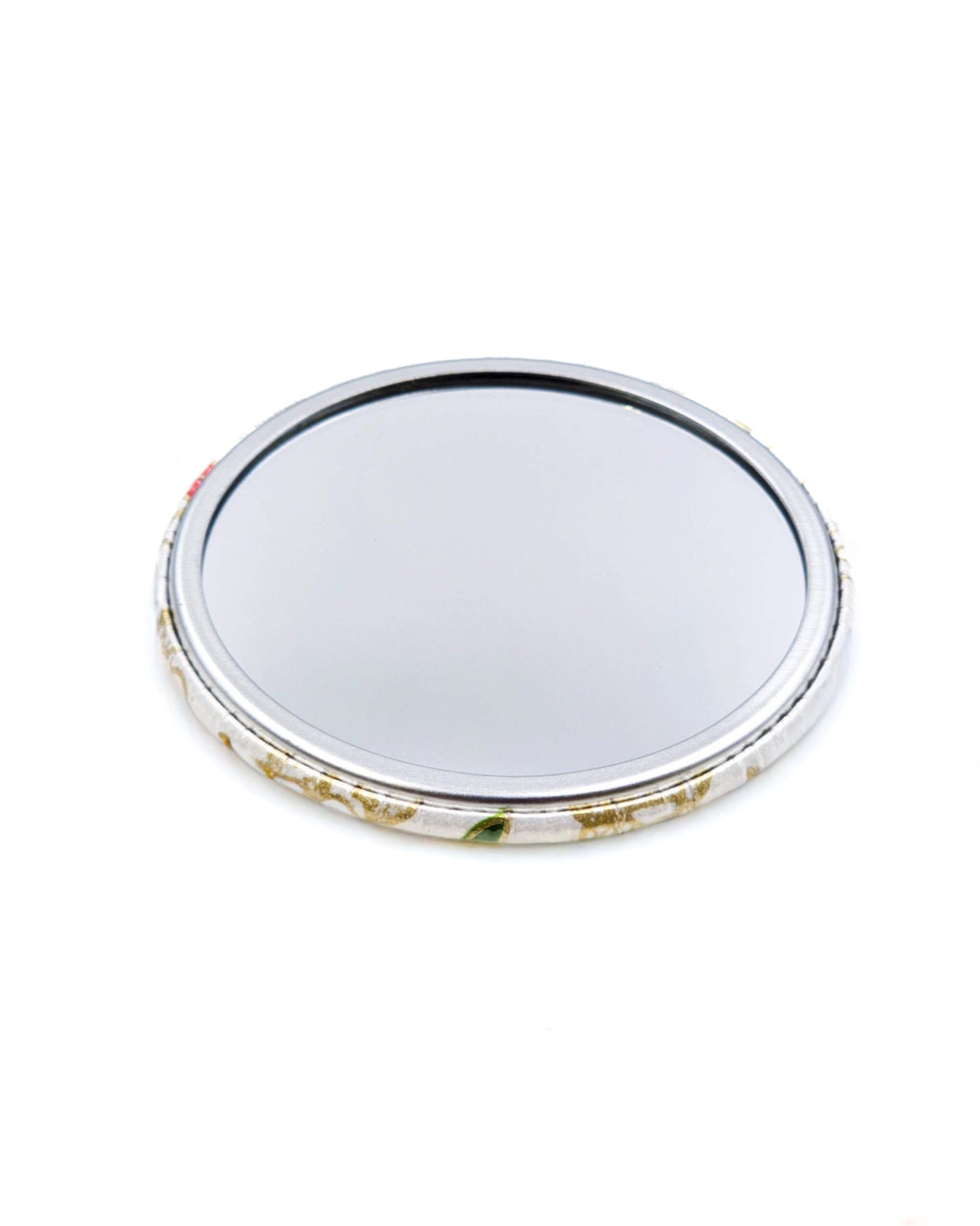 Round pocket mirror featuring a cute red, green, and white dragon on a white background with metallic gold accents.