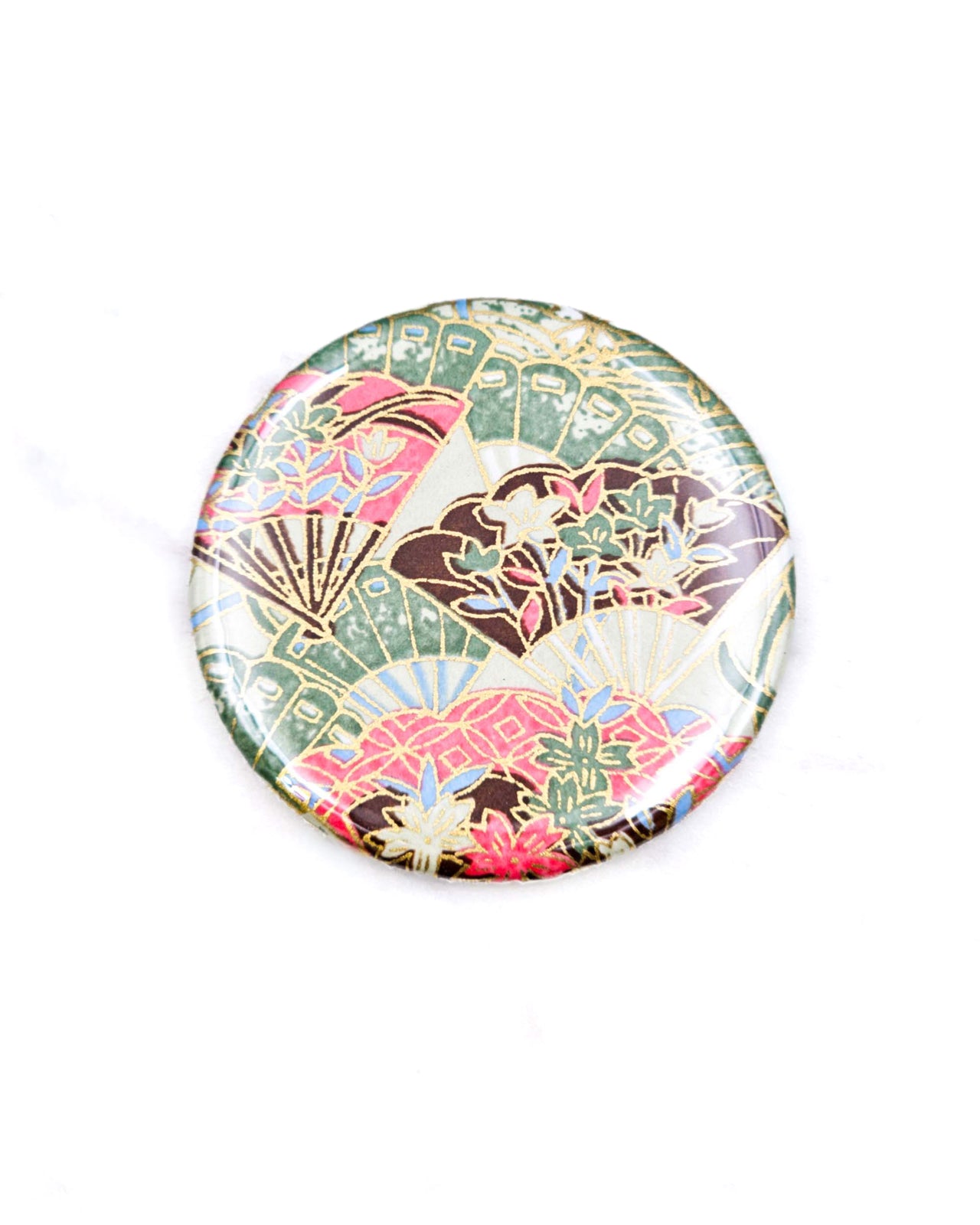 Round pocket mirror featuring green, pink, and brown floral hand fans on a green background with metallic gold accents.