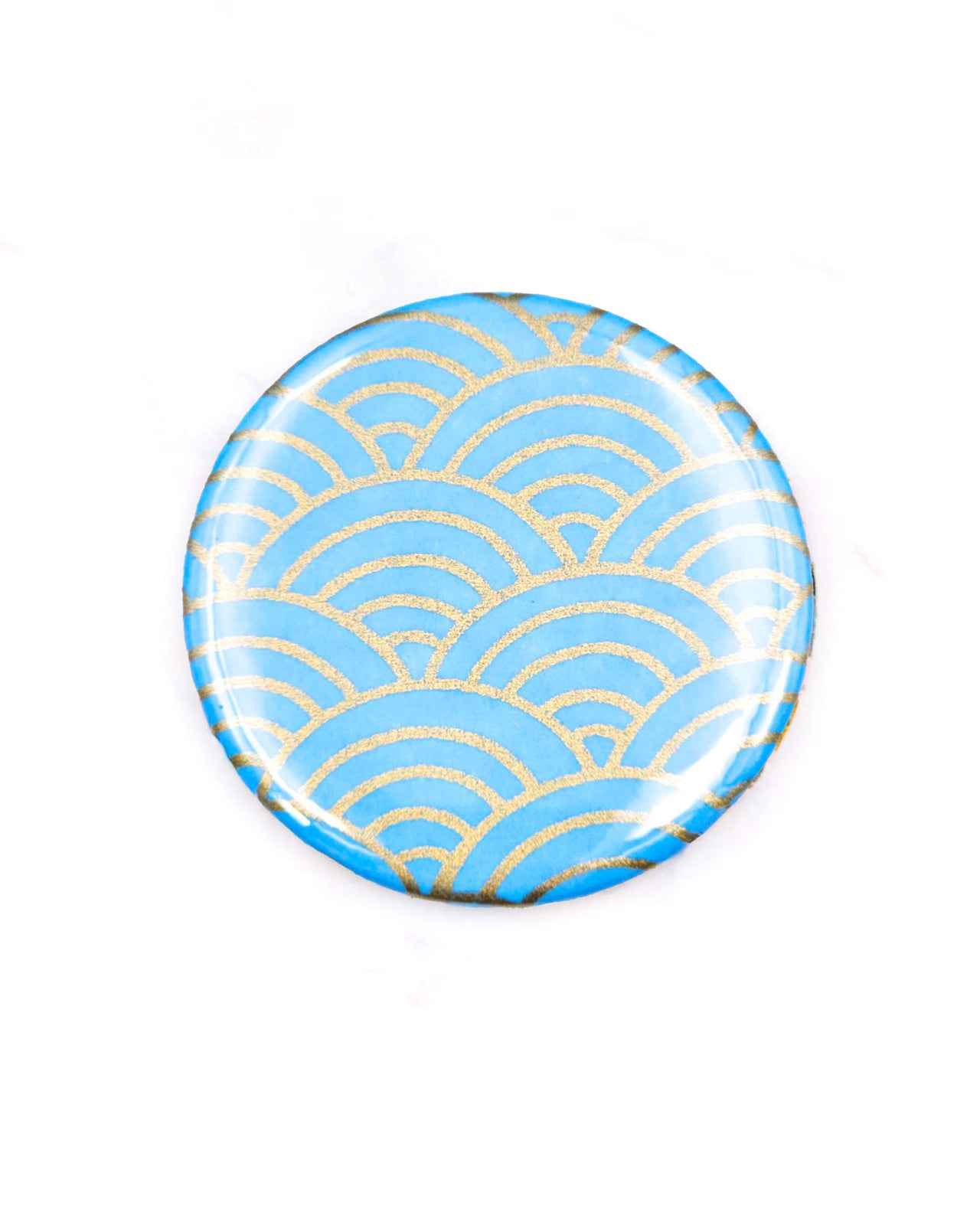 Round pocket mirror featuring a traditional metallic gold and light blue seigaiha (wave crest) design.