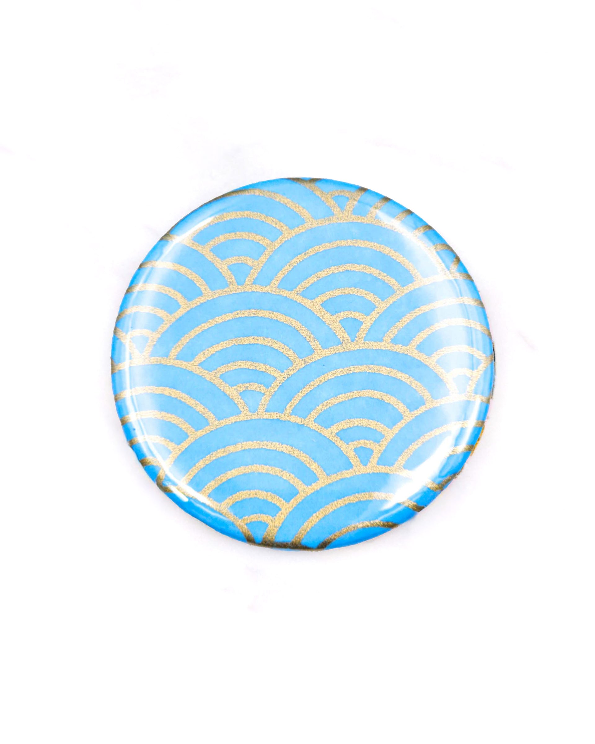 Round pocket mirror featuring a traditional metallic gold and light blue seigaiha (wave crest) design.