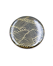 Round pocket mirror featuring metallic gold waves on a black background.