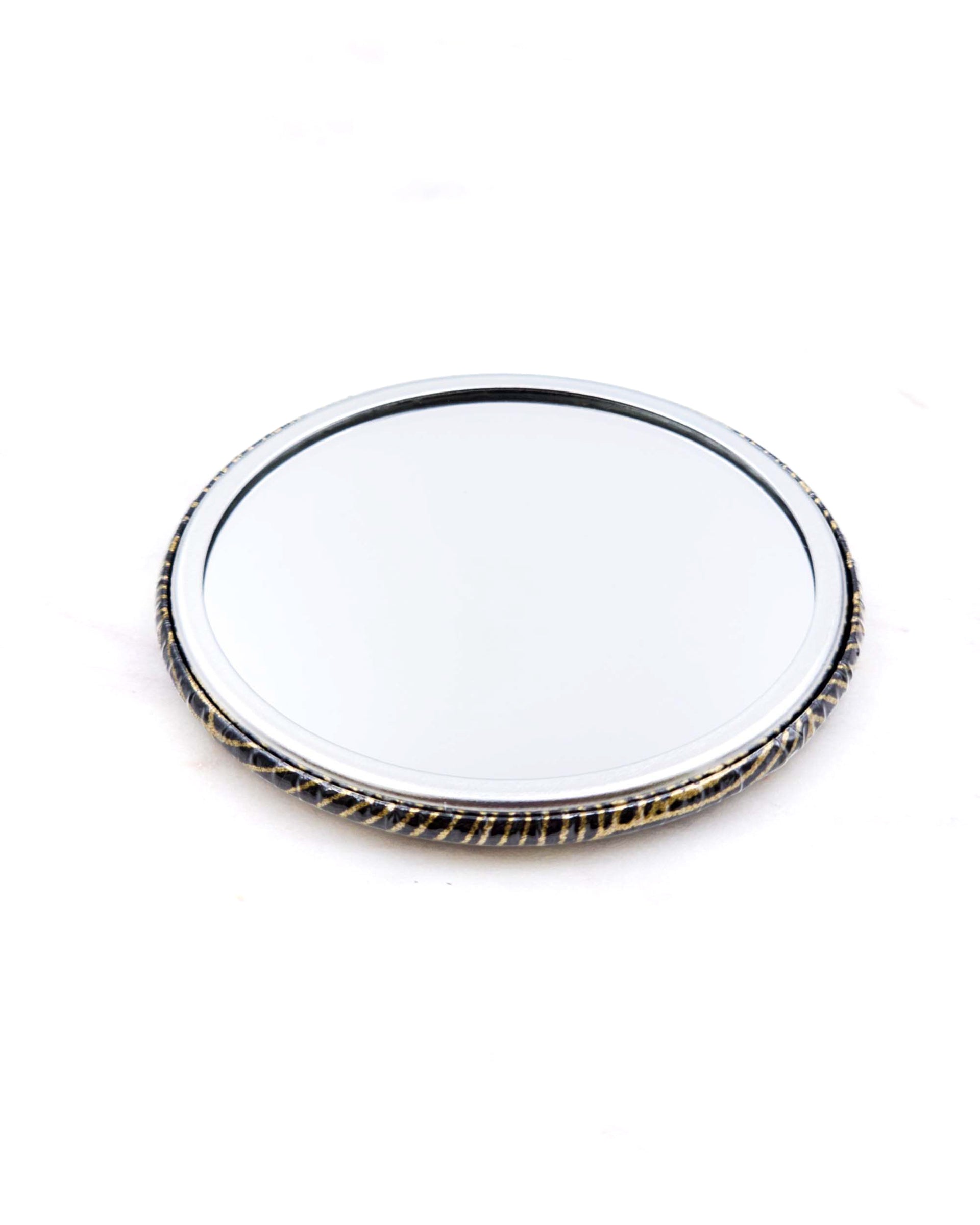 Round pocket mirror featuring metallic gold waves on a black background.