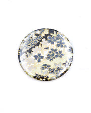 Round pocket mirror featuring gray and white cherry blossoms and other flowers on a gray and white background with metallic gold accents.