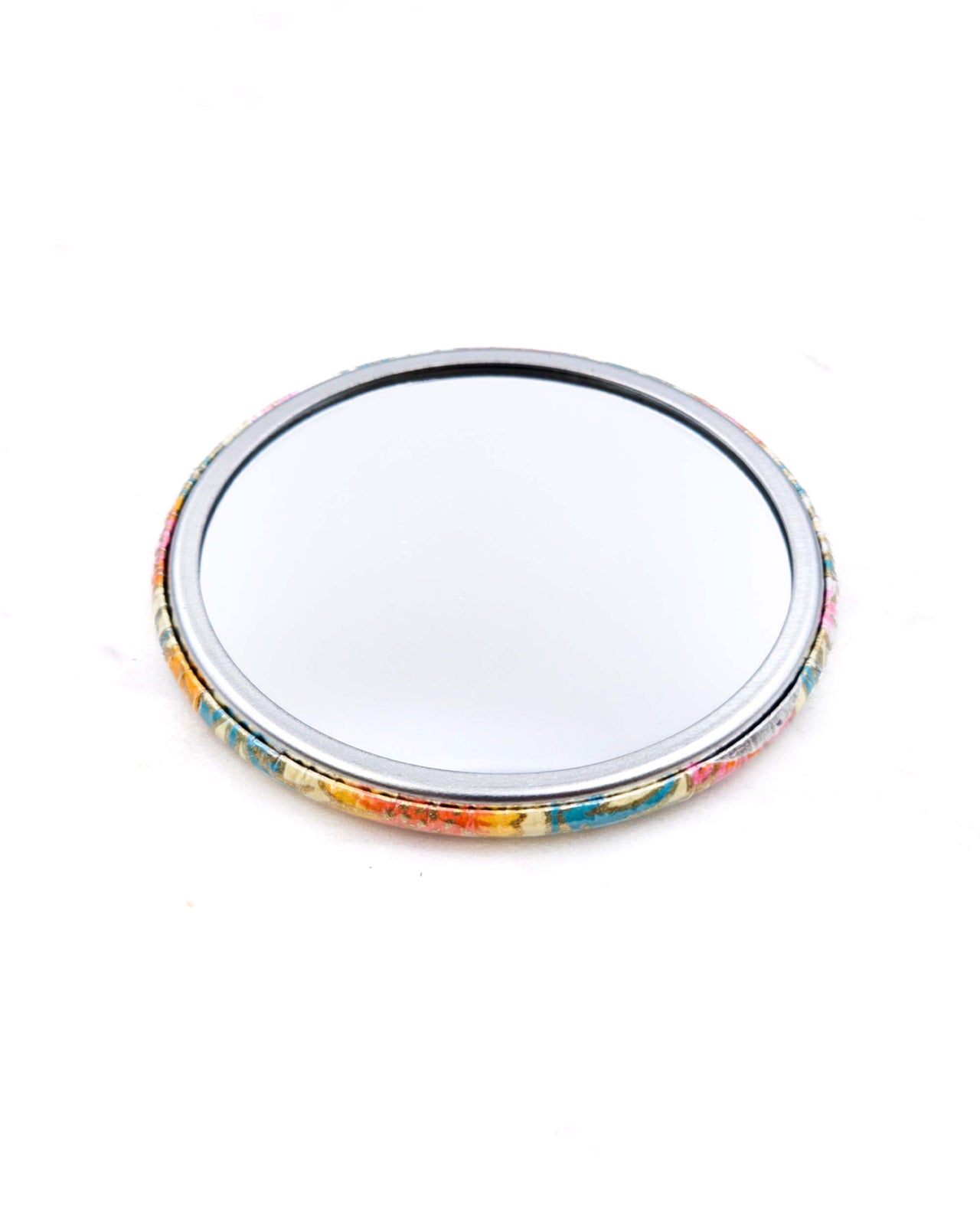 Round pocket mirror featuring orange and white flower stalks on a beige background with metallic gold accents.