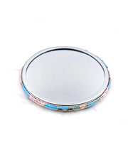Round pocket mirror featuring a pink plum blossoms on a light blue background with metallic gold accents.