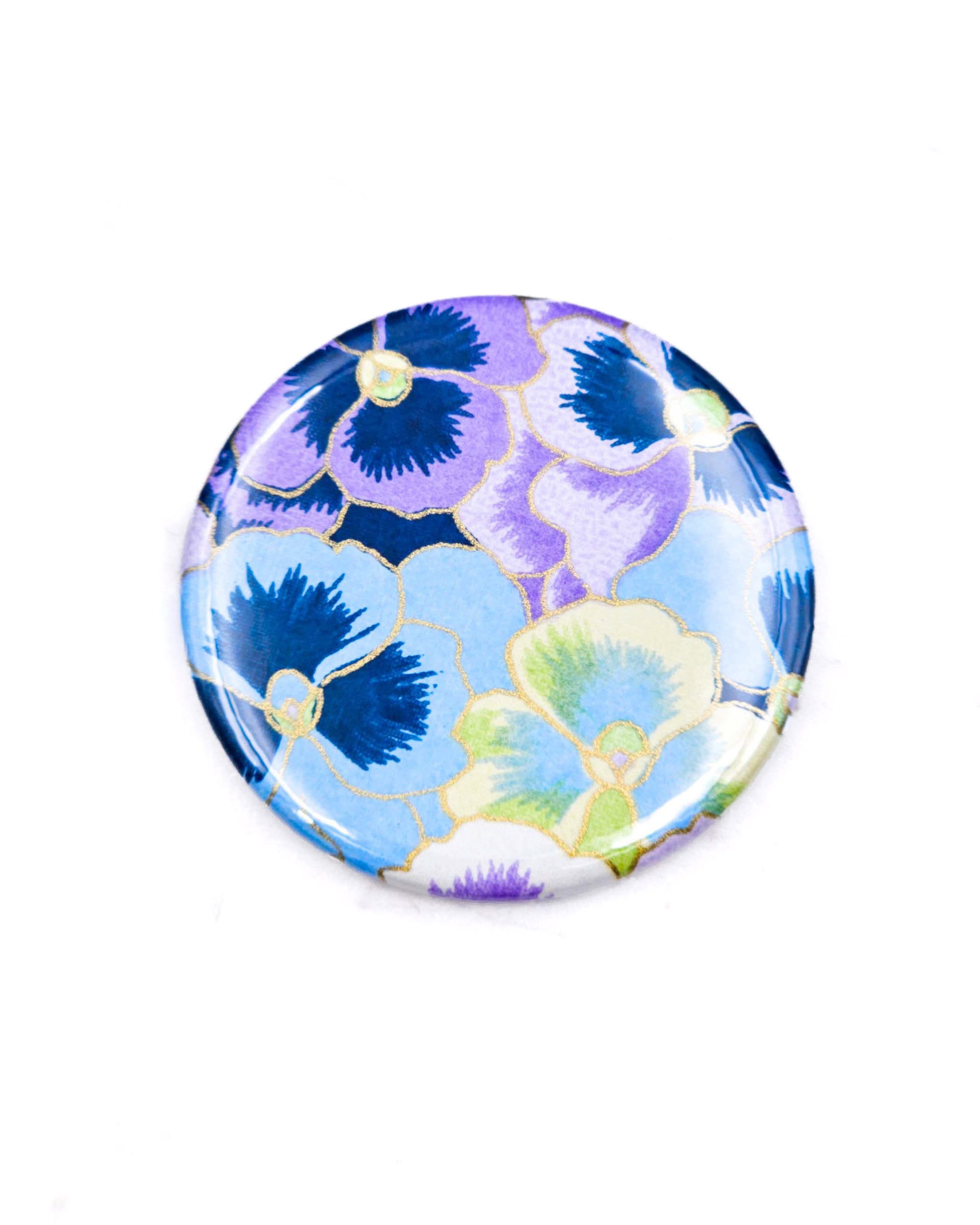 Round pocket mirror featuring purple, blue, and green pansies with metallic gold accents.