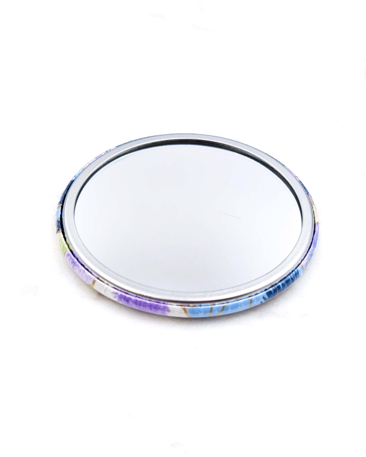 Round pocket mirror featuring purple, blue, and green pansies with metallic gold accents.