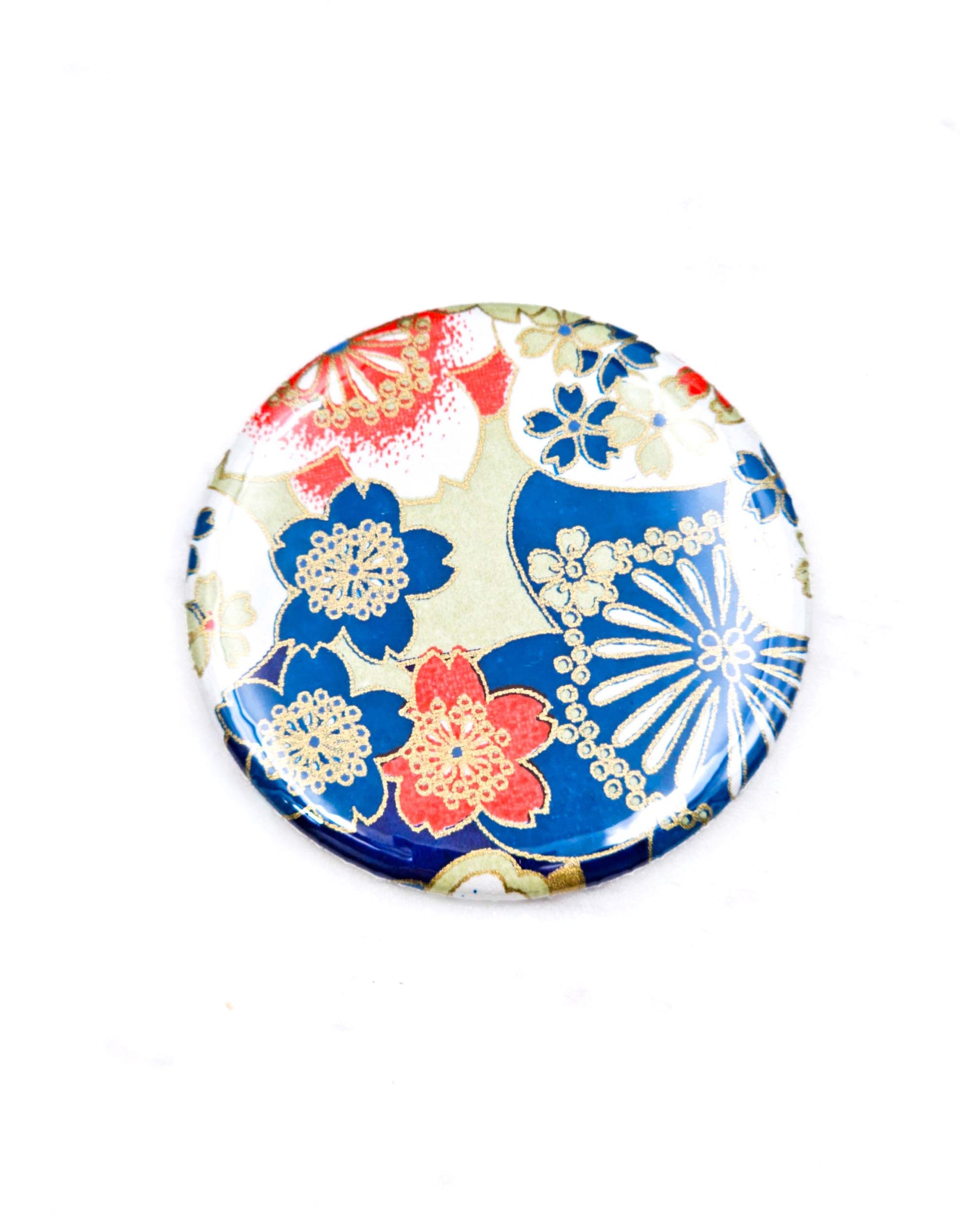 Round pocket mirror featuring red, blue, and white cherry blossoms with metallic gold accents.